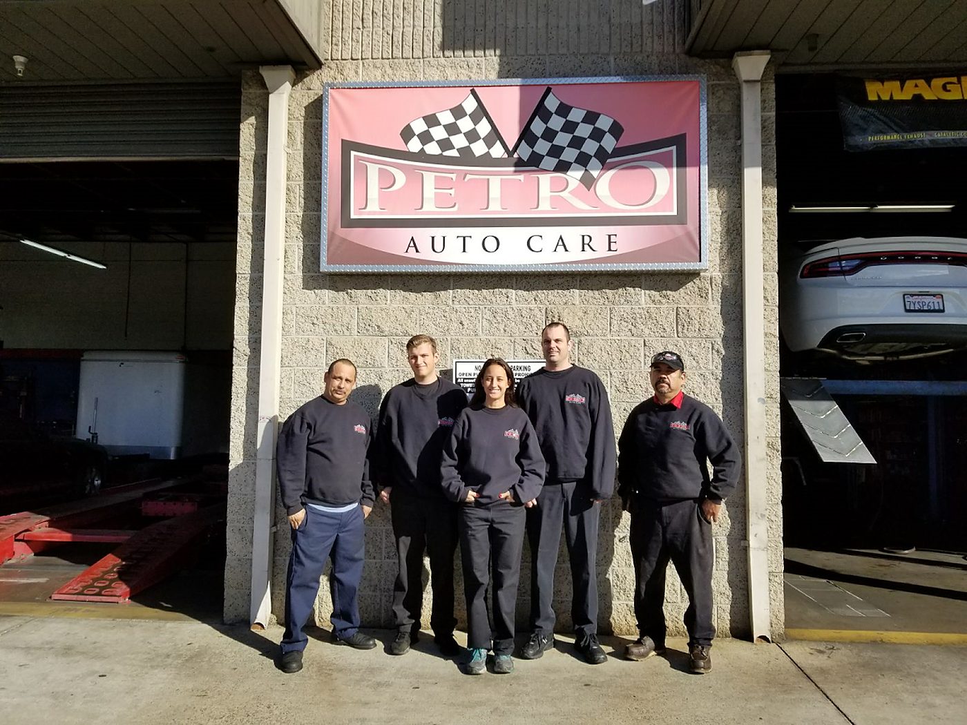 The Petro Auto Care team in front of the shop sign